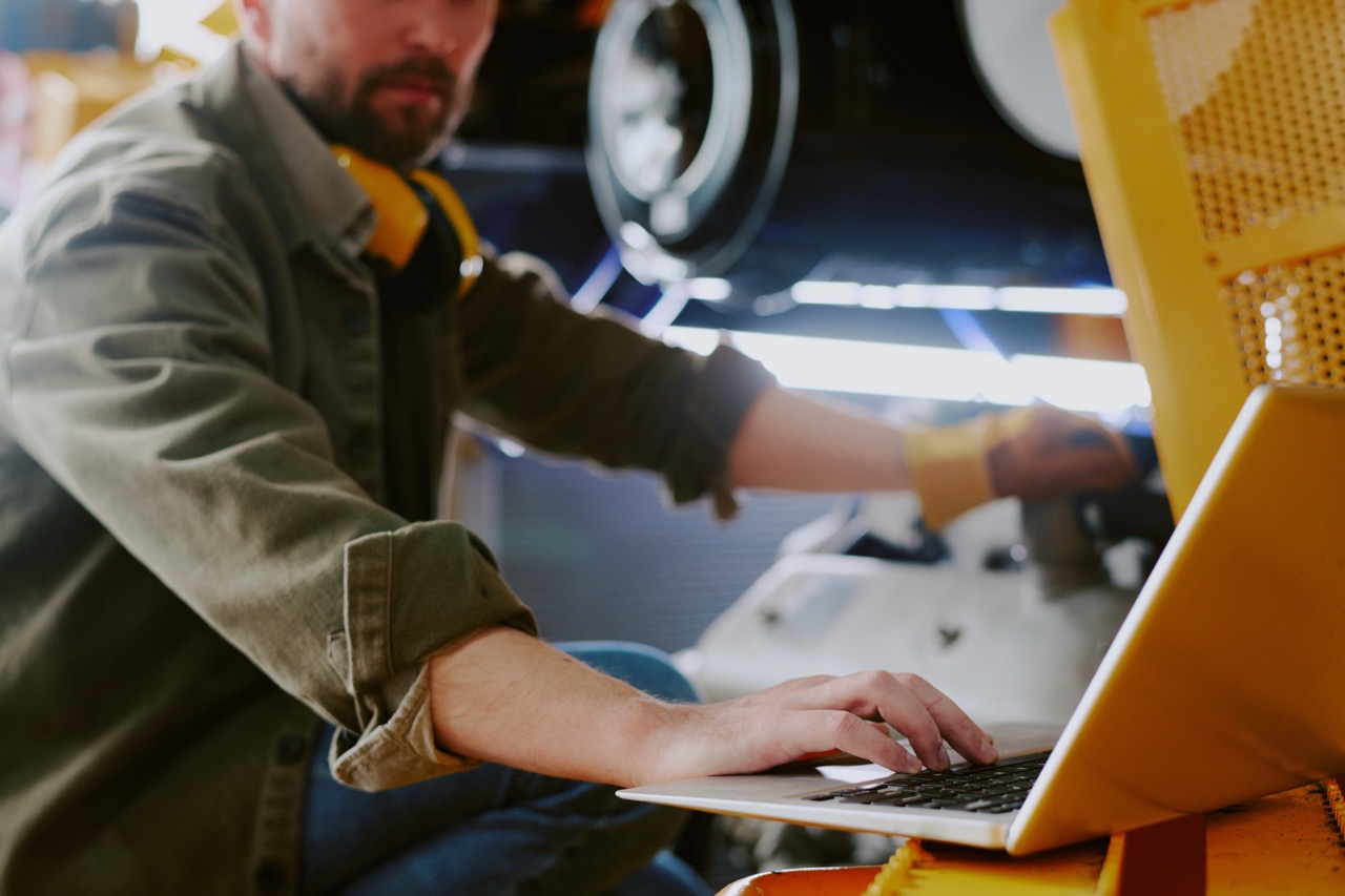 Männlicher Techniker arbeitet mit Laptop – Diagnosis Tool analysiert IO-Link Signale elektrisch und logisch.